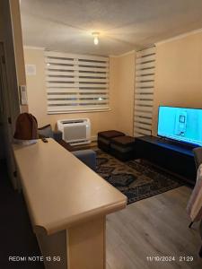 un soggiorno con un divano e una televisione di Departamento en excelente lugar para descansar a Puerto Montt