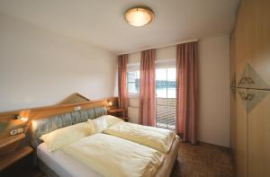 una camera da letto con un letto con una grande finestra di Maltschacher Seewirt a Feldkirchen in Kärnten