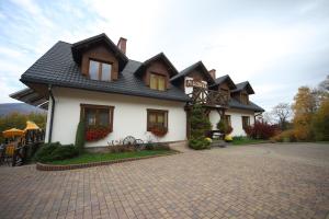 ウストロンにあるMileżówka - Noclegi&SPAの黒屋根の大白い家