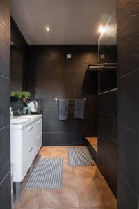 a bathroom with black walls and a sink and a counter at denis salvà montjuic in Barcelona +41 photos