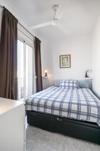 a white bedroom with a bed and a window at denis salvà montjuic in Barcelona