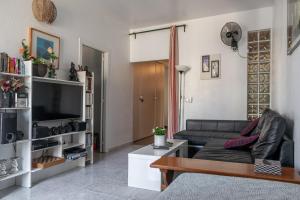 a living room with a couch and a tv at denis salvà montjuic in Barcelona