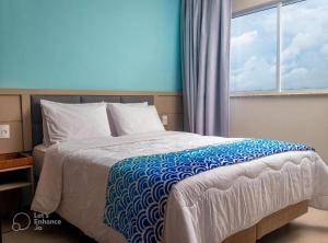 a bedroom with a bed with a blue and white blanket at Aqualand Resort 2 quartos até 6 pessoas in Salinópolis +8 photos
