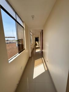 an empty hallway with a window in a building at Habitaciones Chincha in Sunampe