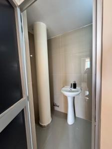 a bathroom with a sink and a pillar at Habitaciones Chincha in Sunampe