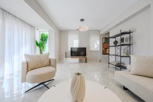 a living room with a couch and a tv at Foothills Turquoise Villa in Sfakaki