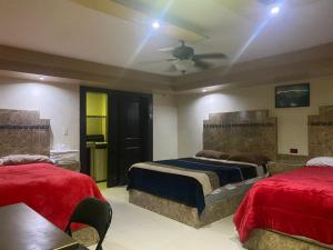 a bedroom with two beds and a ceiling fan at hotel angeles in San Luis Río Colorado
