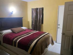 a bedroom with a bed and a window and a door at hotel angeles in San Luis Río Colorado