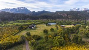 een luchtzicht op een boerderij met bergen op de achtergrond bij El Rincón in Trevelín