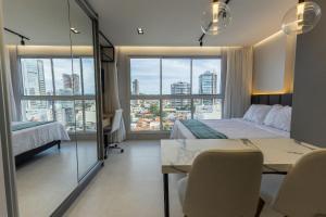 a bedroom with a bed and a table with chairs at Estúdios modernos no City House by WeHousy in Barreiras +94 photos
