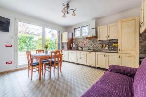 a kitchen with a table and chairs and a purple couch at Piano Terra Moderno con Ampi Spazi e Luminosità in Carpi