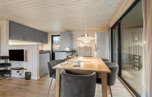 una cucina e una sala da pranzo con tavolo e sedie di Holiday Home Fanø 18 a Fanø