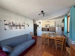 un salon avec un canapé bleu et une table dans l'établissement 4 Pièces pour 8 pers avec balcon et casier à skis à Superdevoluy - FR-1-504-438, à Superdevoluy