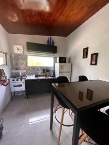 a kitchen with a table and a kitchen with a stove at Casa La chueca in Punta Colorada