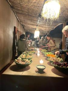 a long table filled with bowls of food at Touaregs Camp Erg Lihoudi in Mhamid