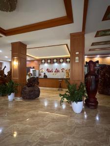a lobby with a vase and potted plants at Khách sạn Vĩnh Lộc in Lao Cai