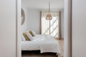 a bedroom with a bed with white sheets and a window at Premium Penthouse with Unmatched Views in Estepona +27 photos