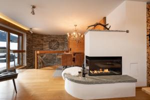 a living room with a fireplace and a dining room at Luxus Ferienwohnung Almhütte in Brixen im Thale