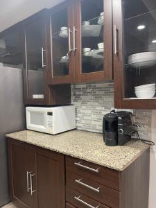 a microwave sitting on a counter in a kitchen at 3 bedroom central location montreal close to airport in Laval