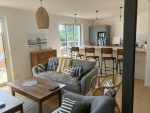 a living room with two couches and a kitchen at Chez David à Paimpol in Paimpol