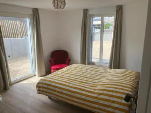 a bedroom with a bed and a window and a chair at Chez David à Paimpol in Paimpol
