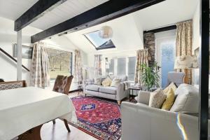 a living room with a white table and chairs at Rowan Studio Cottage in Grasmere