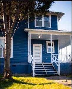une maison bleue avec une porte blanche et des escaliers dans l'établissement Blue Corner Luxe, Timeless Charm Near Downtown, à Little Rock
