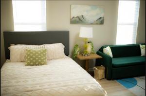 - une chambre avec un lit et une chaise verte dans l'établissement Blue Corner Luxe, Timeless Charm Near Downtown, à Little Rock