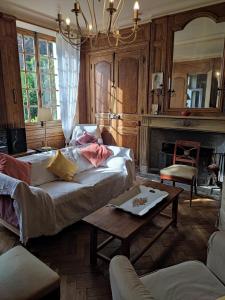 ein Wohnzimmer mit Sofa und Tisch in der Unterkunft L' Aphelide in Sablons-sur-Huisne