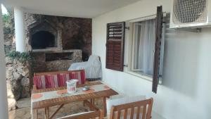 a wooden table and chairs with a stone oven at 5 srca in Stanići