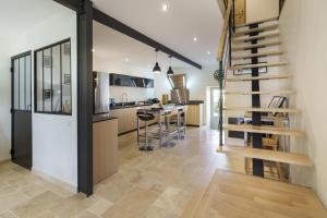 a kitchen and living room with a spiral staircase at Gîte 1694 - 4 étoiles - proche Futuroscope in Scorbé-Clairvaux