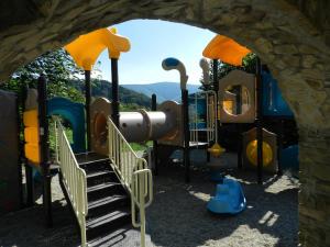 a playground with a slide and stairs in a park at Mileżówka - Noclegi&SPA in Ustroń