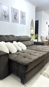 a black leather couch in a living room at Casa das borboletas in Matinhos