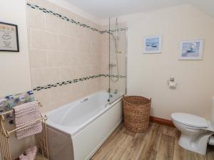 bagno con vasca e servizi igienici di Old Hall Cottages ad Ashbourne Altre 14 foto
