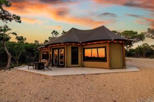 a small house with a black roof in the desert at Love Shack at Mystic Hills Ranch in Fischer
