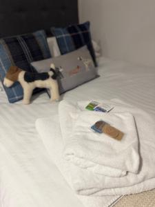 a bed with towels and a stuffed animal on it at Chloes Retreat in Norwich