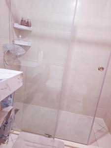 une douche avec une porte vitrée dans une salle de bain dans l'établissement Tranquil Waves Residence, à Assilah