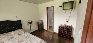 a bedroom with a bed and a television on the wall at Casa de campo Rega in Falan