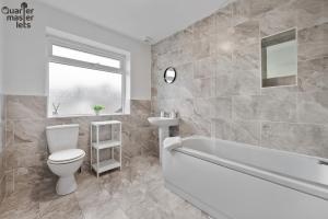ein Badezimmer mit Toilette, Badewanne und Waschbecken in der Unterkunft 5 Bedroom Central Townhouse with Parking that Sleeps 9 in Leamington Spa