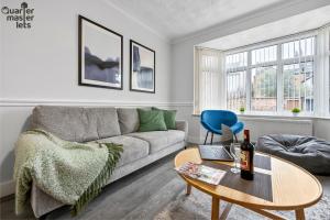 ein Wohnzimmer mit Sofa und Tisch in der Unterkunft 5 Bedroom Central Townhouse with Parking that Sleeps 9 in Leamington Spa