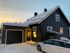a house with a car parked in front of it at Tromsø - seksjonert hus i nydelige omgivelser in Trondalen +7 photos