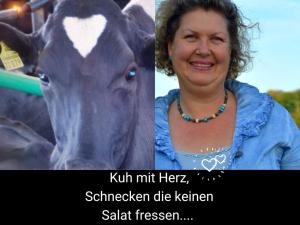 a woman is standing next to a cow at Kleine einzigartige Ferienwohnung auf dem Bauernhof, direkt in der Natur mit Blick auf Schloss Braunfels in Braunfels