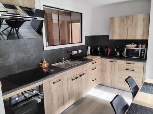 a kitchen with a sink and a microwave at Appartement au cœur du kochersberg in Kienheim +3 photos