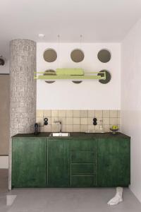 a kitchen with green cabinets and a sink at Wolne Pokoje I Boutique Apartments in Wrocław