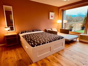 a bedroom with a bed and a couch and a window at Casa Treveris II in Trier