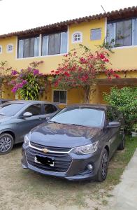 two cars parked in front of a house at Guest House Renascer K&W in Cabo Frio