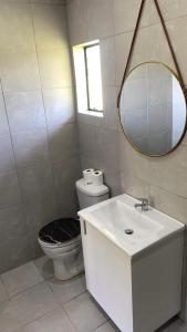 a bathroom with a toilet and a sink and a mirror at Pinetown Accommodation in Pinetown