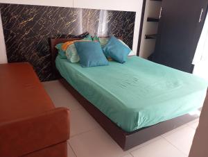 a bed with blue pillows in a room at Full House in Girardot +8 photos