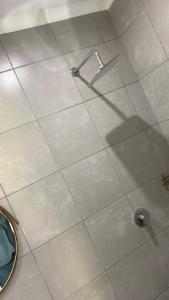 a shower with a faucet on a tiled floor at Pinetown Accommodation in Pinetown