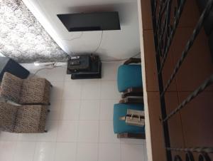 a bathroom with blue chairs and a ceiling at Full House in Girardot
